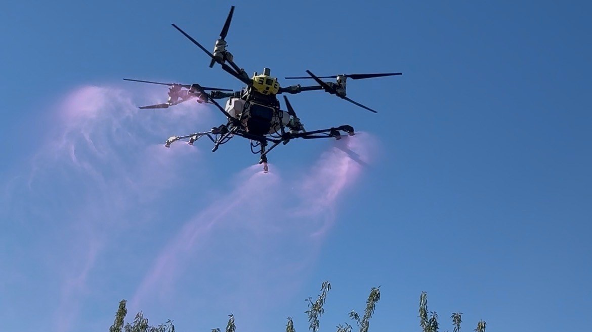 Stony Creek Ag spray drone applying product over an orchard canopy